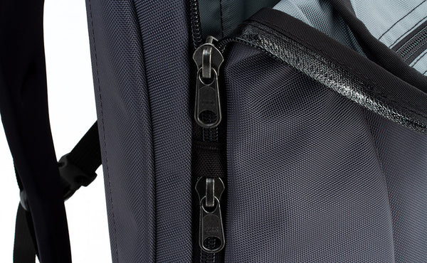 A close shot of where the side pocket and main pocket zippers meet.